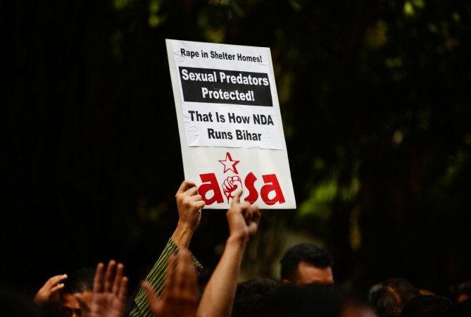 An Indian activist holds a placard during a protest over the sexual assault of girls at a state-run home in eastern India city, near Bihar Bhawan in New Delhi on July 30, 2018. Protest against Muzaffarpur shelter home
