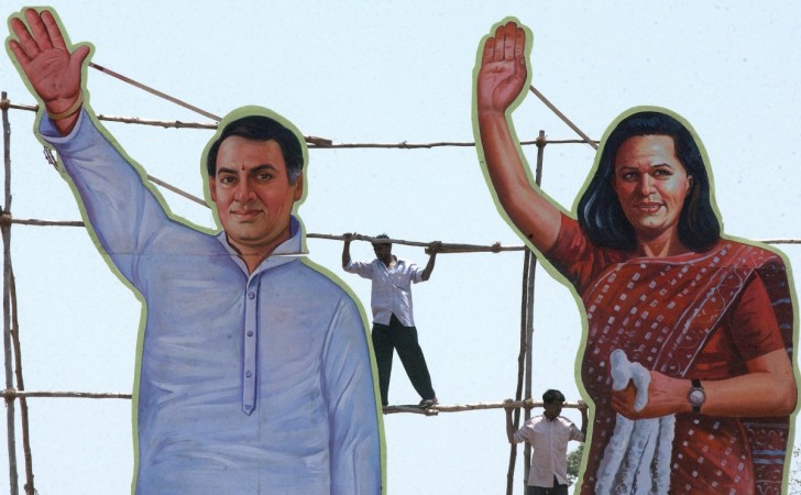 Supporters of the Congress party climb on a scaffolding where a cut-outs of Indian Opposition Leader and Congress Party President Sonia Gandhi (R) and her late husband Rajiv Gandhi (L) are displayed during an election rally in Kolar, 16 April 2004 some 70 kms north-west of Bangalore. Scaffolding of Congress