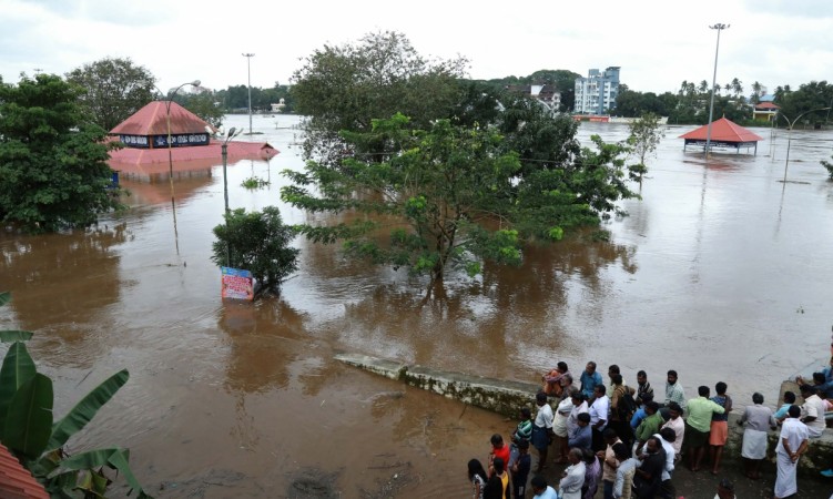 Indian residents look at the Shiva Temple submerged after the release of water from Idamalayar dam following heavy rains in Kochi on August 9, 2018. - At least 20 people were killed on August 9 in landslides triggered by heavy rains in southern India, an official said, pushing the nationwide monsoon death toll for this year to over 700. Kerala floods