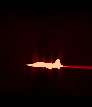 A U.S. Air Force Test Pilot School T-38 is captured, using a special filtered camera on the ground, flying in front of the sun. Shockwaves are seen beginning to form as the vehicle transitions from a subsonic speed to supersonic Sonic boom