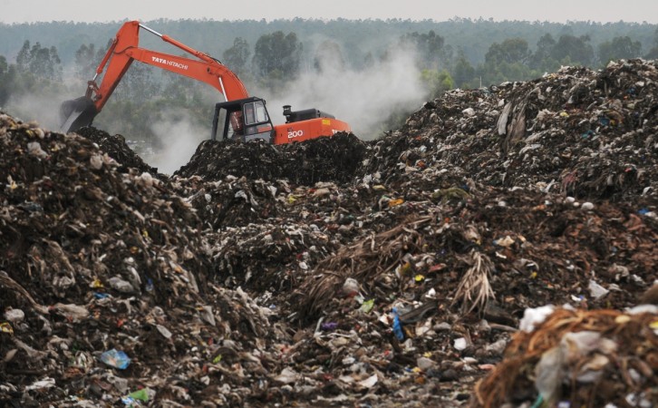 Excavator levels heaped waste at the city's largest legal municipal waste landfill in Mavallipura village on the outskirts of IT capital Bangalore, on April 20, 2010. April 22 marks the 40th Earth Day, which urges local action and increased awareness to understand and respect the environment. India, with its 1.2 billion citizens, faces challenges from rapid urbanisation and industrialisation, such as pollution, sanitation and water supply, as well as degradation of forests and agricultural lands, and is already the world's fifth largest carbon emitter despite a low per capita share. landfill