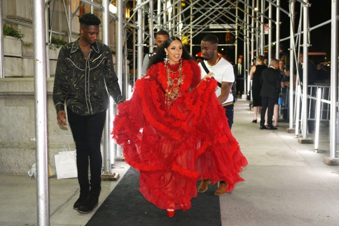 Cardi B pictured here in a red voluminous gown at a New York Fashion Week party. Cardi B