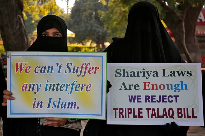 Muslim women display placards during a protest against a bill passed by India's lower house of Parliament that aims at prosecuting Muslim men who divorce their wives through the Triple talaq ban