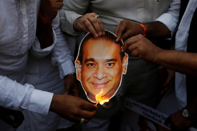 Activists of the youth wing of India's main opposition Congress party burn a cut-out with an image of billionaire jeweller Nirav Modi. Nirav modi