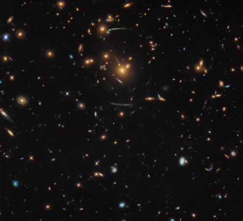 This NASA/ESA Hubble Space Telescope image contains a veritable mix of different galaxies, some of which belong to the same larger structure: At the middle of the frame sits the galaxy cluster SDSS J1050 0017 Gravitational lensing