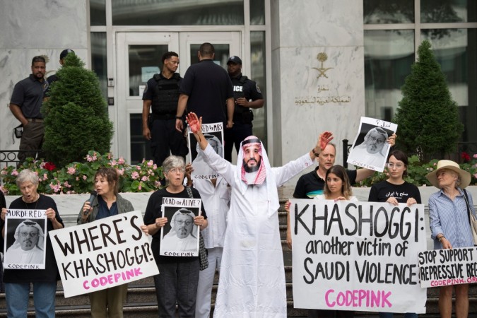 A demonstrator dressed as Saudi Arabian Crown Prince Mohammed bin Salman (C) with blood on his hands protests with others outside the Saudi Embassy in Washington, DC Jamal Khashoggi