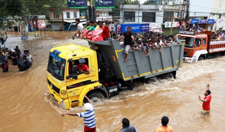 Passengers travel in a truck to a safer place as flood waters ravaged the National Highway 47 in Ernakulam district of Kochi on August 17, 2018 Kerala Floods