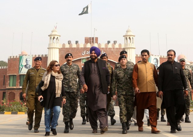 India's Punjab cabinet minister and former cricketer Navjot Singh Sidhu (4th L) walks after entering Pakistan from India at the border crossing in Wagah on November 27, 2018. - Sidhu arrived in Pakistan to attend the groundbreaking ceremony of the Kartarpur Corridor in Nankana Sahib scheduled for November 28. kartarpur
