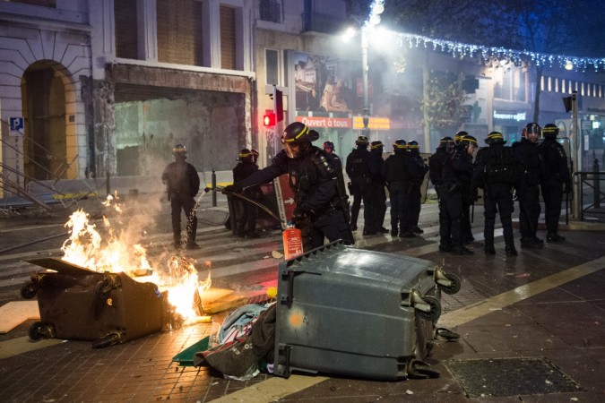 Riot police extinguish a fire during a demonstration by Yellow Vests (Gilets jaunes) against rising oil prices and living costs in Marseille on December 1, 2018. france unrest