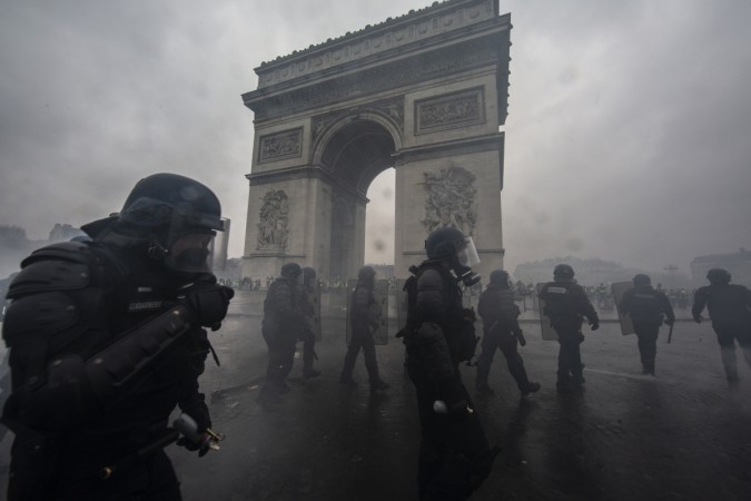 Teargas surrounds riot police as they clash with protesters during a 'Yellow Vest' demonstration near the Arc de Triomphe on December 1, 2018 in Paris, France. Paris Riots