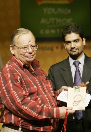 Indian author Ruskin Bond (L) is watched by Rupa &Co. publisher Kapish Mehra as he poses with a book of short stories entitled 'Post Box no. 99' in New Delhi 11 May 2005. ITC together with Rupa & Co. have launched 'Post Box no.99' a compilation of 12 award-winning short stories submitted by school children in the Classmate Young Author Contest (CYAC) Ruskin Bond