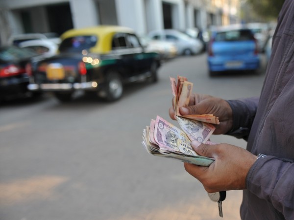A parking lot employee counts Indian rupee notes in New Delhi on December 15, 2011. The Indian rupee continued its downward spiral against the US dollar on Thursday, hitting another record low due to concerns over the eurozone debt crisis and weak domestic data. The Indian unit -- Asia's worst performing currency this year -- fell to a low of 54.3 to the dollar, extending a slide that has seen it lose more than 20 percent of its value against the greenback in 2011. Indian rupee