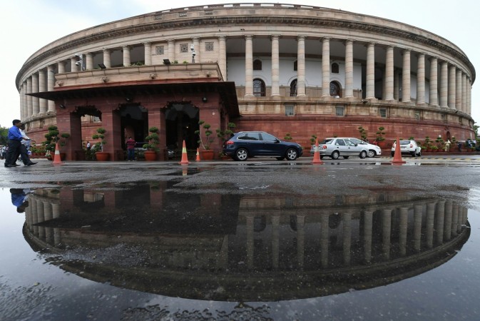 The Indian Parliament building is reflected in a puddle after heavy rain during the monsoon session of the Indian Parliament in New Delhi on July 20, 2018. The markets will be watching the progress and intensity of the monsoon while consolidating the gains after the elections. (Photo by Prakash SINGH / AFP) The Indian Parliament building