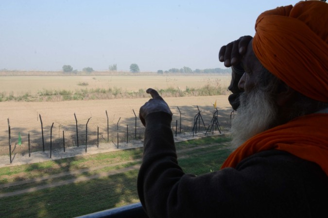 An Indian Sikh devotee points out towards the Gurdwara Kartarpur Sahib, which is situated in Pakistan, from Indian side at Dera Baba Nanak on the outskirts of Amritsar on November 25, 2018. (Photo by NARINDER NANU / AFP) Nanak-Kartarpur Sahib corridor to the Kartarpur Sahib Gurdwara across the border