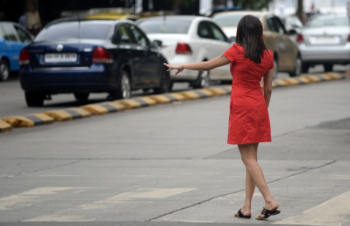 In this photograph taken on June 15, 2015, an Indian woman hails a cab at a business district in Mumbai. India published new guidelines for web-based ride-hailing firms including US-based Uber and its local rival Ola on December 16, 2015, after months of legal battles and bans over rising concerns for the safety of women passengers. There has been extensive soul-searching in India about the frightening levels of violence against women since an infamous gang-rape on a bus in Delhi in December 2012 in which the victim later died of her injuries. Women's safety in India has not improved since the fatal gang-rape of a student in New Delhi, that sparked international outrage. AFP PHOTO/ Indranil MUKHERJEE / AFP PHOTO / Indranil MUKHERJEE an Indian woman hails a cab at a business district in Mumbai.