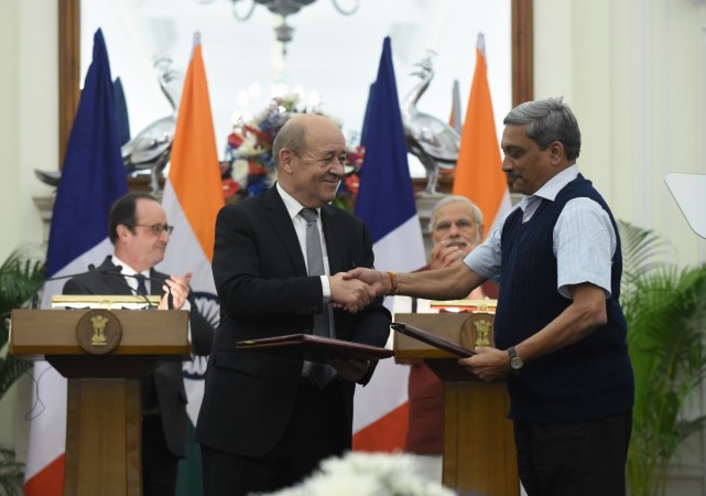 French Defence Minister Jean-Yves Le Drian (2nd L) and his Indian counterpart Manohar Parrikar (R) shake hands as they exchange intergovernmental agreements for the purchase of 36 Rafale jet fighters at a joint press conference between Prime Minister Narendra Modi (2nd R) and French President Francois Hollande (L) in New Delhi on January 25, 2016. AFP PHOTO / Prakash SINGH / AFP / PRAKASH SINGH Rafale deal