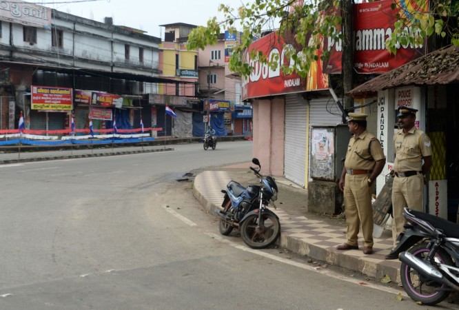 Indian police stand guard during a statewide strike called by Hindu groups in Adur in the southern state of Kerala on November 17, 2018, as tens of thousands of pilgrims headed for the nearby Sabarimala temple that the Supreme Court ordered to be opened to women of all ages, which has prompted protests from Hindu traditionalists. Kerala hartal