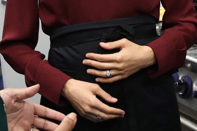 Meghan Markle cradles her baby bump Meghan Markle