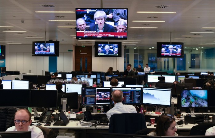 Traders work at the offices of CMC Markets in the City of London on December 10, 2018, as Britain's Prime Minister Theresa May makes a statement in the House of Commons announcing the government's intention to delay the 'meaningful' vote on the Brexit withdrawal agreement. - British Prime Minister BRITAIN-EU-POLITICS-BREXIT-ECONOMY-CURRENCY-MARKETS