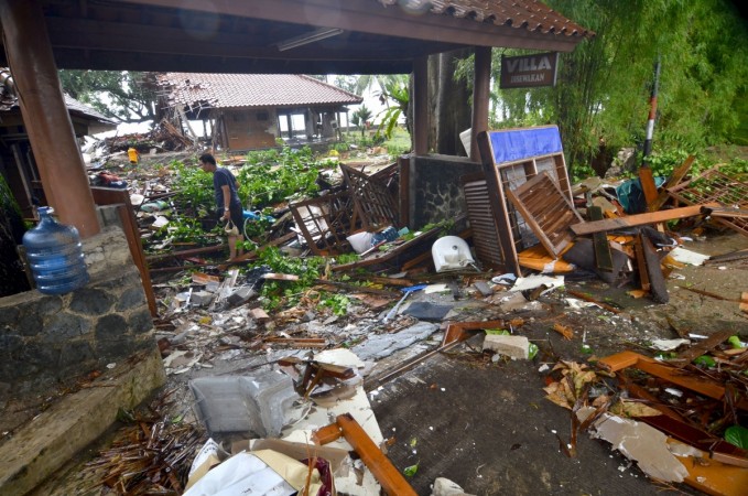 A man walks amid debris from damaged buildings in Carita on December 23, 2018, after the area was hit by a tsunami on December 22 following an eruption of the Anak Krakatoa volcano. indonesia tsunami