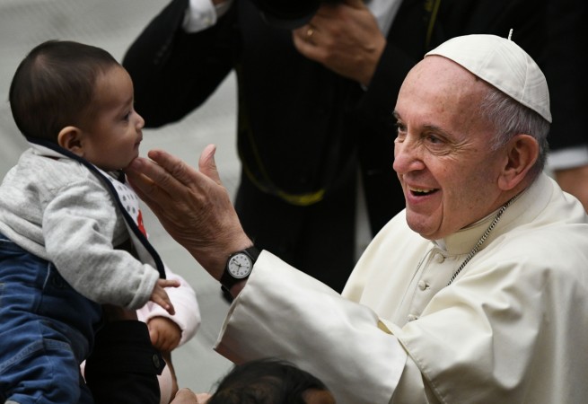 Pope Francis fondles a baby's head during an audience for children and families of the Santa Marta dispensary on December 16, 2018 at the Vatican. (Photo by Vincenzo PINTO / AFP) VATICAN-POPE-AUDIENCE-CHILDREN-SANTA MARTA