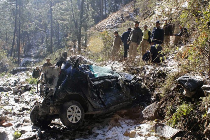 Police are seen gathered near the wreckage of a car which fell into a gorge at Tutikandi near Shimla on January 21, 2012. Five people were killed when a car in which they were travelling skidded off the road and plunged into a 1,000-foot (300m) gorge at Tutikandi, reports said. AFP PHOTO/STR Police are seen gathered near the wreckage of a car which fell into a gorge at Tutikandi near Shimla