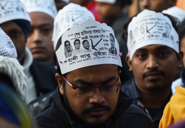 Supporters of the Jatiya Party, an alliance partner of ruling Prime Minister and Awami League-led chief Sheikh Hasina, are seen holding posters outside a polling station in Dhaka on December 30, 2018. - Bangladesh headed to the polls on December 30 following a weeks-long campaign that was dominated by deadly violence and allegations of a crackdown on thousands of opposition activists. bangladesh election
