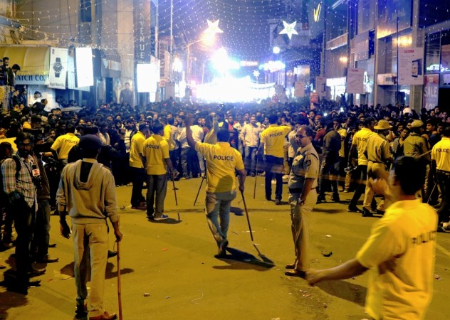 In this photograph taken on January 1, 2017, Indian police personnel holding 'lathi' sticks try to manage crowds during New Year's Eve celebrations in Bangalore on January 1, 2017. An Indian minister faced a severe backlash January 3 after he criticised women for dressing 'like westerners' at a New Year's eve celebration where a mob allegedly carried out a series of sex assaults. Although police have yet to charge anyone in connection with the violence on New Year's Eve in Bangalore, local media have carried testimony and photos of victims cowering from their attackers or fleeing for safety. / AFP PHOTO / STR Indian police personnel holding 'lathi' sticks try to manage crowds during New Year's Eve celebrations in Bangalore on January 1, 2017.