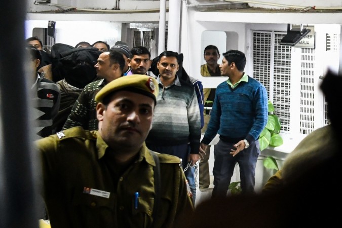 An agent of the National Investigation Agency (NIA) escorts suspected members (with masks) of a militant group 'Harkat ul Harb-e-Islam' outside the Patiala Court in New Delhi on December 27, 2018. Harkat ul Harb-e-Islam