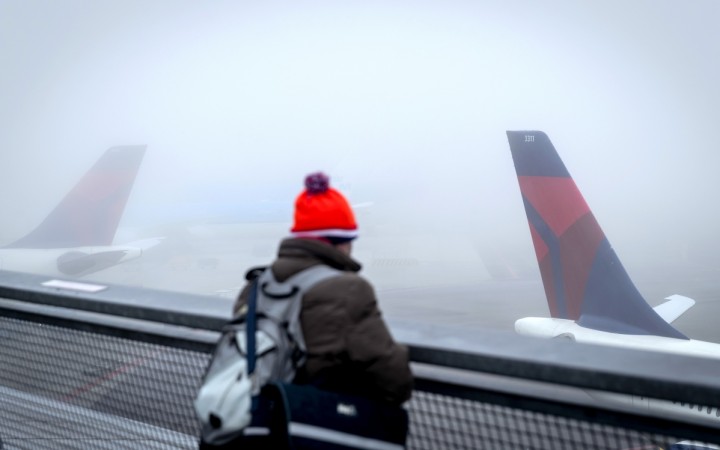 A person watches planes on the tarmac at the Schiphol Airport, The Netherlands, on December 28, 2016 on a foggy day. / AFP / ANP / Robin van Lonkhuijsen / Netherlands OUT A person watches planes on the tarmac at the Schiphol Airport, The Netherlands, on December 28, 2016