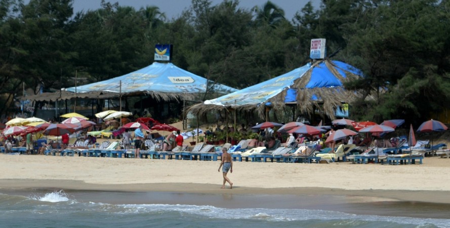 A tourist walks past a row of sunbeds on Baga Beach in Goa on March 14, 2008. Police in the Indian coastal state of Goa confirmed they have charged two men with the murder of a British teenager Scarlett Keeling, 15, who was fed with a deadly cocktail of drugs, raped by one of the men and then left for dead on the Anjuna beach tourist spot. The two suspects were named as local barman Samson D'Souza, 29, and Placido Carvalho, an alleged drugs dealer working the beaches of the former Portuguese colony. AFP PHOTO/Sajjad HUSSAIN goa