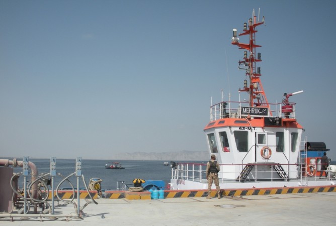 In this photograph taken on October 4, 2017, a Pakistani army soldier stands guard at Gwadar port. Remote and impoverished, Pakistan's Gwadar port at first glance seems an unlikely crown jewel in a multi-billion dollar development project with China aimed at constructing a 21st century Silk Road. Situated on a barren peninsula in the Arabian Sea, Gwadar, or the 'gate of the wind', owes its fortuitous selection as Pakistan's next economic hub to its strategic location near the Strait of Hormuz. gwadar port pakistan
