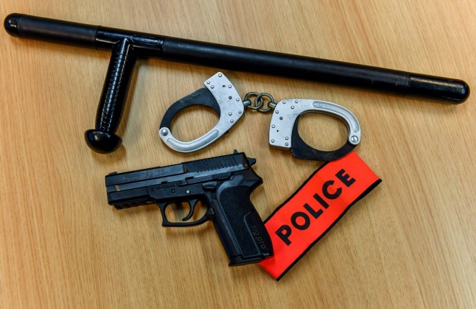 A photo taken on November 29, 2018, at the police headquarters in Lille, northern France, shows a gun, handcuffs and a truncheon. handcuffs
