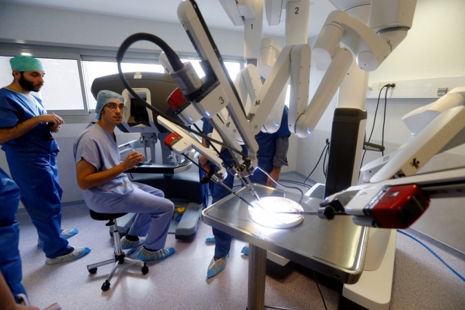 TO GO WITH AFP STORY BY ELIZABETH ZINGG A surgeon sits at the console of the 'Da Vinci Xi' surgical robot during its presentation on November 26, 2014 at the Gustave Roussy Institute, Europe's leading cancer treatment centre, in Villejuif, south of Paris. With four articulated arms fitted with cameras and surgical instruments, a surgeon controls this latest generation of surgical robots from a console equipped with joysticks and pedals, and benefits of a three-dimensional image in high-definition. robot surgery