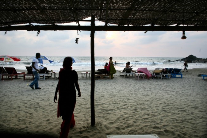 People walk along Vagator beach in Goa on March 17, 2008. Goa, a main touristic area accounts for nearly 12 percent of the four million tourists who visit India yearly. Goa