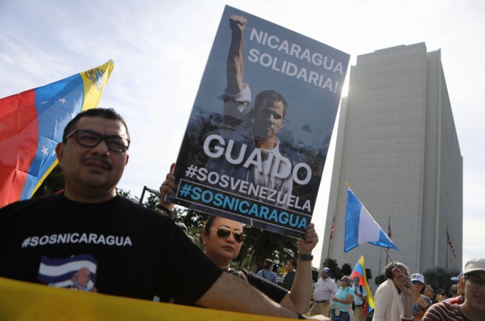 Anti-Maduro demonstrators gather as one holds a poster of Venezuelan opposition leader Juan Guaido, outside the Federal Building, on January 26, 2019 in Los Angeles, California. The protestors called for Guaido to be installed as the head of state of Venezuela. Some Nicaraguan protestors joined the demonstration in solidarity. Anti-Maduro protests in united states