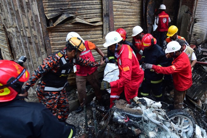 Rescue personnel carry the body of a victim after a fire broke out in Dhaka on February 21, 2019. - At least 69 people have died in a huge blaze that tore through apartment buildings also used as chemical warehouses in an old part of the Bangladeshi capital Dhaka, fire officials said on February 21, 2019. BANGLADESH-FIRE