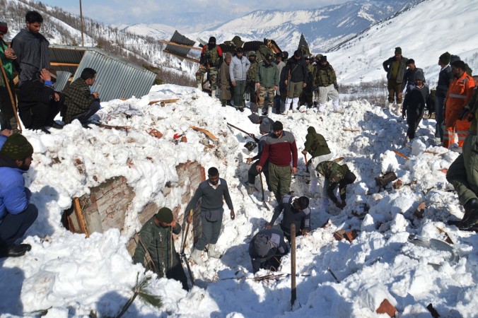 Local residents along with security personnel search the bodies of 10 missing policemen after a snow avalanche hit a police post at Qazigund Jawahar Tunnel in Kulgam district, some 90 km from Srinagar on February 8, 2019. - Three policemen were rescued on February 8 while five other bodies were recovered from an avalanche that buried 10 people in Indian-administered Kashmir following two days of heavy snowfall, police said. INDIA-KASHMIR-WEATHER-AVALANCHE