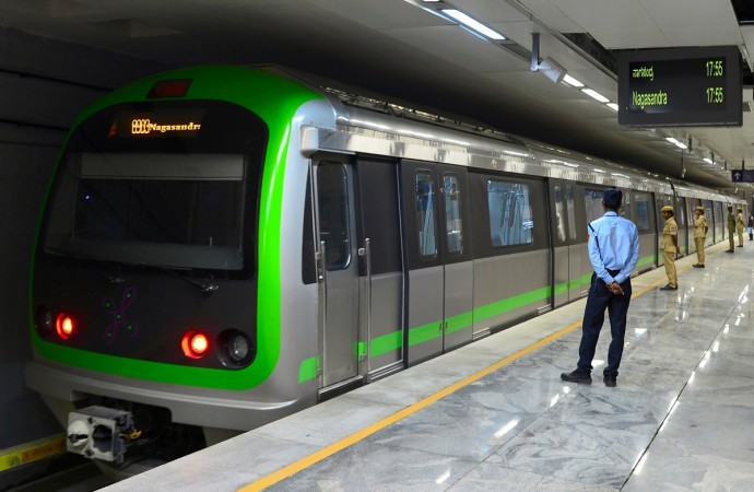 Security personnel watch the trial run of a train running on the yet to be inaugurated Green Line of the Namma Metro Rail at Majestic Station in Bangalore on June 14, 2017. Namma Metro launches its new Green Line on June 17, which completes the Phase 1 of the Bangalore metro project. Security personnel watch the trial run of a train running on the yet to be inaugurated Green Line of the Namma Metro Rail at Majestic Station