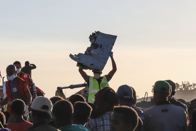 A man carries a piece of debris on his head at the crash site of a Nairobi-bound Ethiopian Airlines flight near Bishoftu Ethiopian air crash