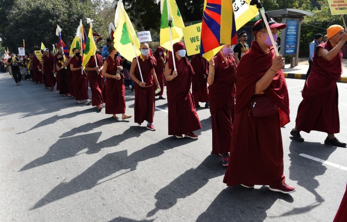 Tibetan exile activists and monks hold Tibetan flags Tibetan exile activists and monks hold Tibetan flags
