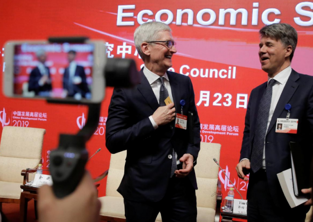 Apple CEO Tim Cook and BMW's Chairman of the Board of Management Harald Krueger attend the China Development Forum in Beijing, China March 23, 2019. Tim Cook and Harald Krueger