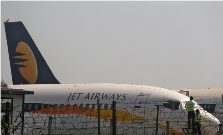 Workers cover the cockpit window of a Jet Airways aircraft parked at the Chhatrapati Shivaji Maharaj International Airport in Mumbai, on March 26. The airline's last flight was on April 17. Jet Airways