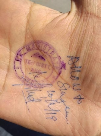 A government employee shows his hand stamped with signature of District Magistrate, Anantnag to allow him to travel to his office in the wake of J&K Highway ban hand stamp