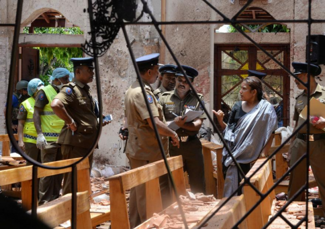 Crime scene officials inspect the site of a bomb blast inside a church in Negombo, Sri Lanka. Sri Lanka blast