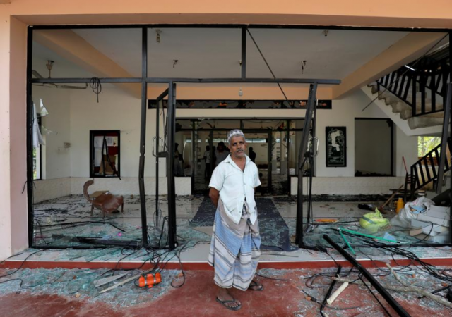 A Muslim man stands in front of the Abbraar Masjid mosque after a mob attack in Kiniyama, Sri Lanka on Monday. Sri Lanka