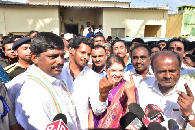 HD Kumaraswamy with his wife and son along with DK Suresh posing for the camera after casting votes. HD Kumaraswamy
