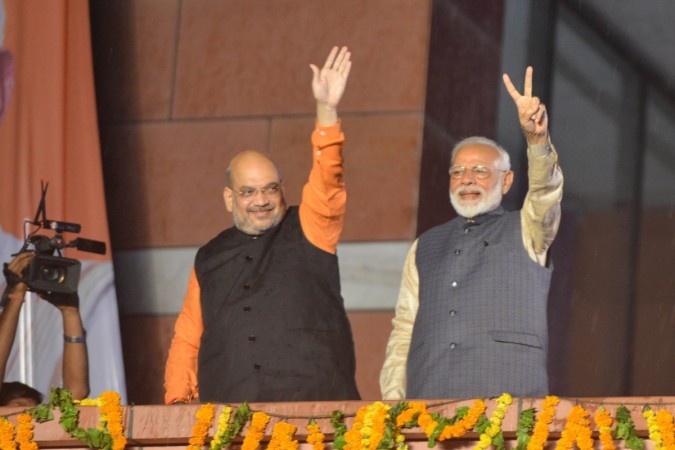 Prime Minister Narendra Modi and BJP chief Amit Shah wave at party workers during a party programme in New Delhi on May 23, 2019. Narendra Modi