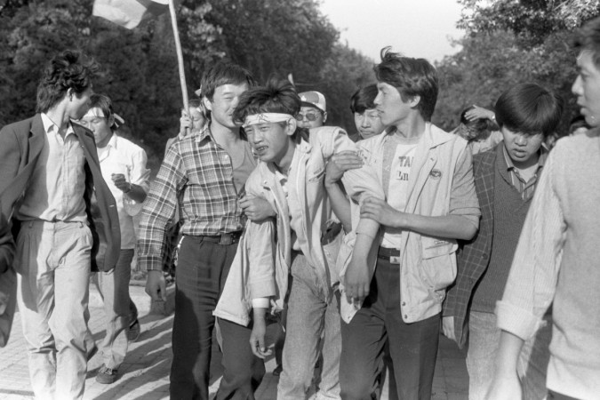 Protesters helped each other as they faced violence by the Communist part's troops in 1989. Tiananmen Square
