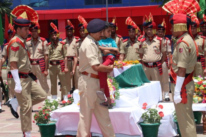 SSP, Srinagar, J&K Police, Haseeb Mughal carrying the son of slain SHO, J&K Police , Arshad Khan during the wreath laying ceremony at Srinagar Arshad Khan